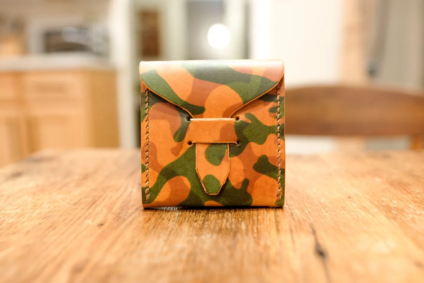 The Woodland Blaze camo pick case, closed and standing on a table