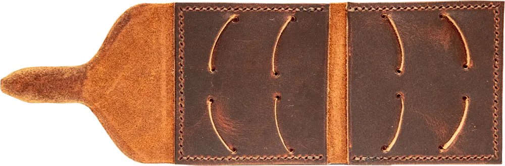 Open flat, eight pick slots cut into smooth brown leather, with a soft suede tongue.