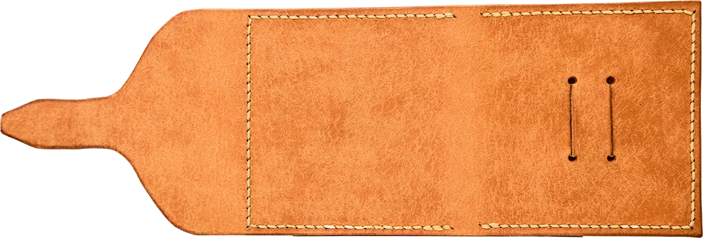 The outside, open flat. One long panel of mottled tan leather with the tongue tapering off to one side.