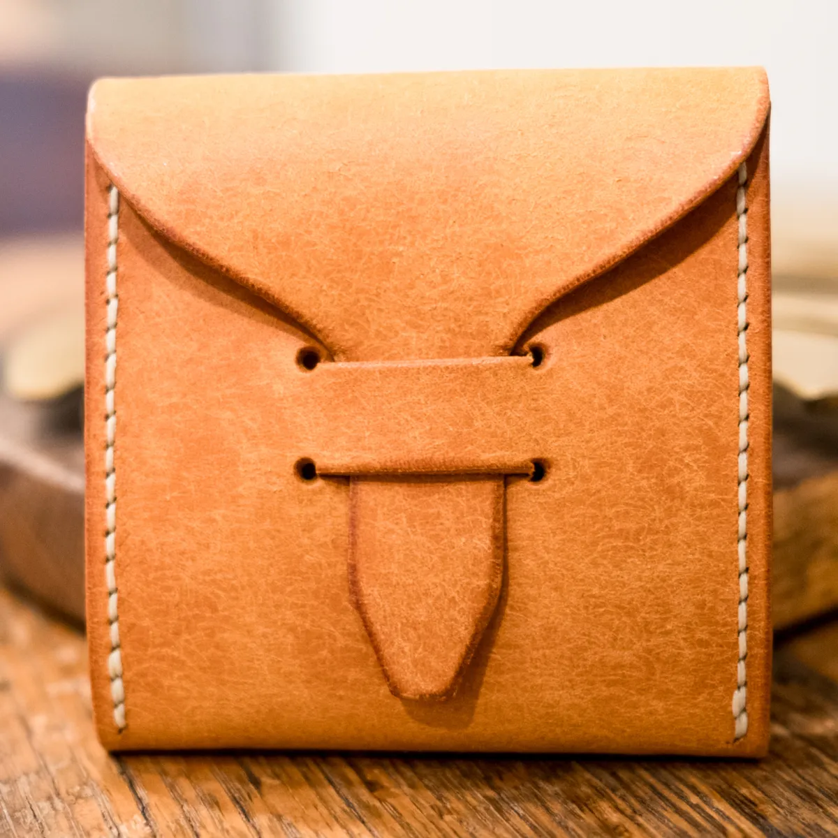 Pueblo Olmo pick case, closed, standing upright on a worn wooden table.